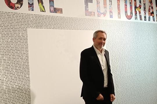 Devant les 5178 noms d’artistes de son catalogue, Guy Delcourt à l’entrée de l’exposition « L’aventure éditoriale ».