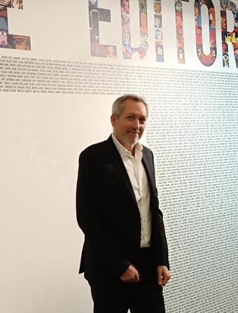 Devant les 5178 noms d’artistes de son catalogue, Guy Delcourt à l’entrée de l’exposition « L’aventure éditoriale ».