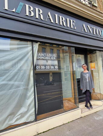 La nouvelle gérante Ingrid Delaetre devant la devanture de l'ancienne librarire Antoine qui deviendra Mon Chat Pitre en avril prochain